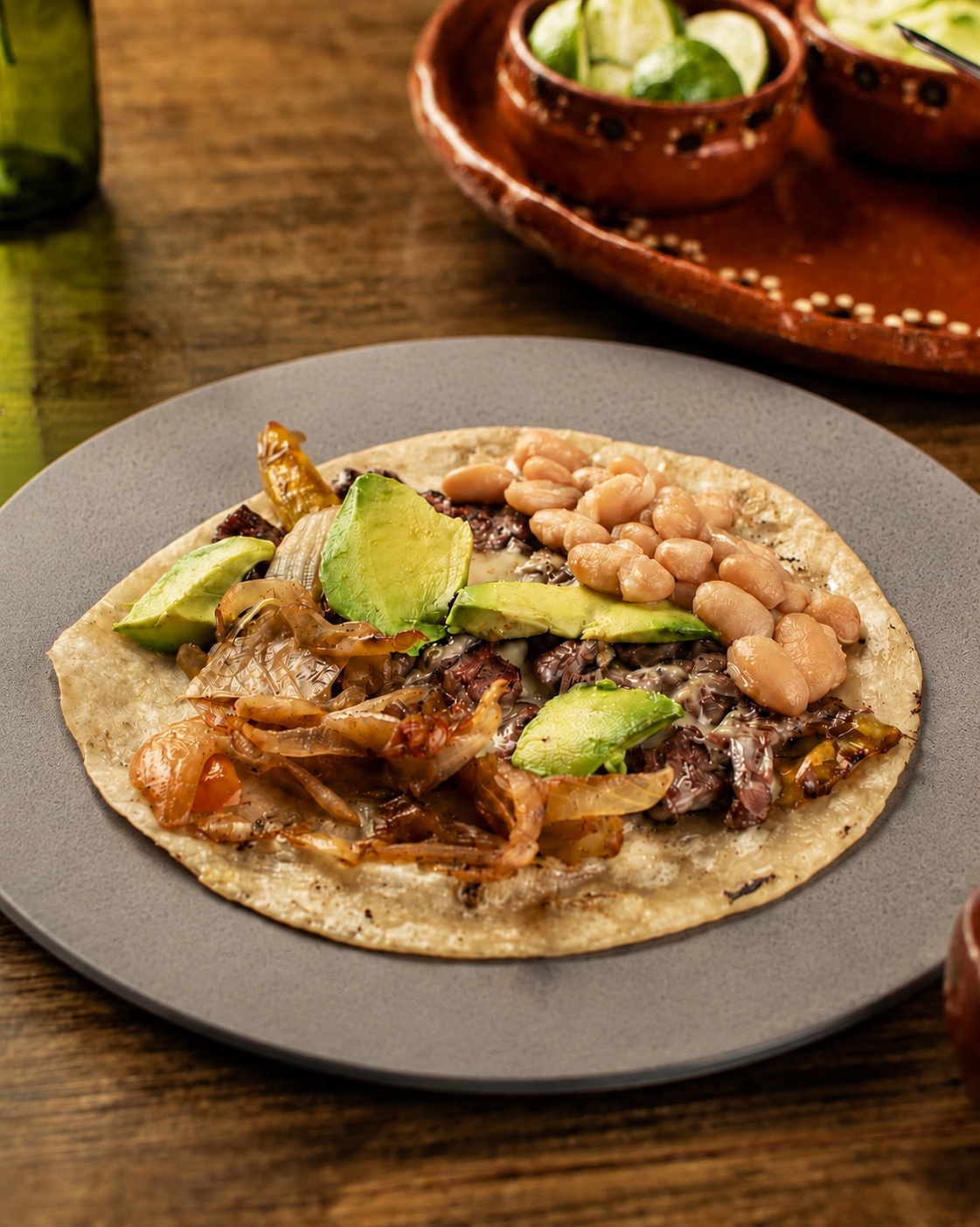 Taco Sonora en tortilla de harina, con arrachera, queso, aguacate, chile Anaheim, frijoles y cebolla